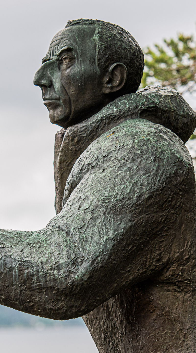Bronze statue of a hiker near lake