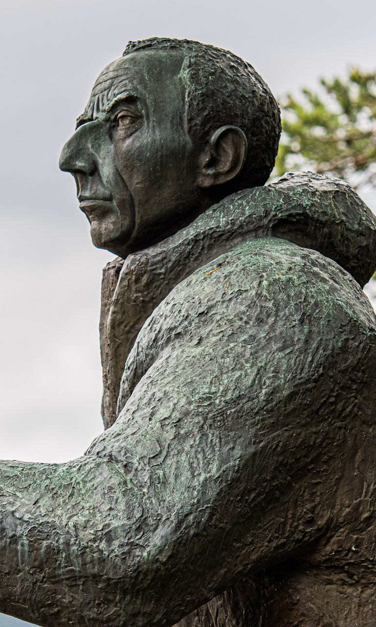 Bronze statue of a hiker near lake