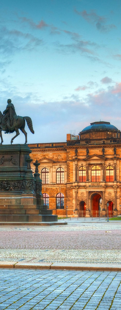 Historic building with equestrian statue at sunset