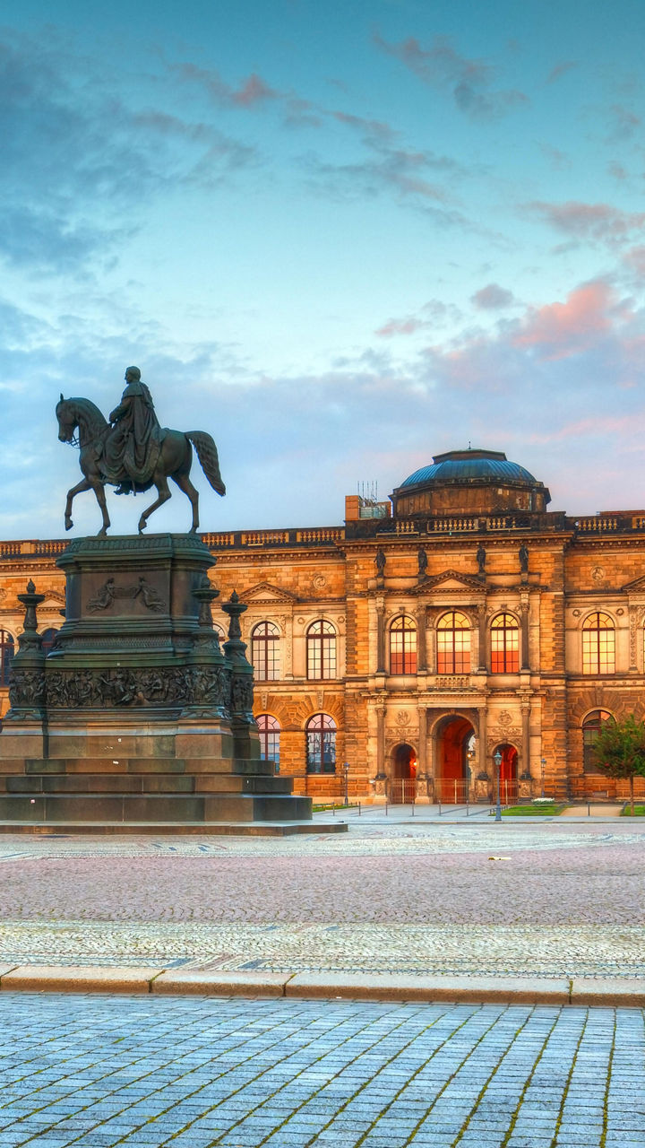 Historic building with equestrian statue at sunset
