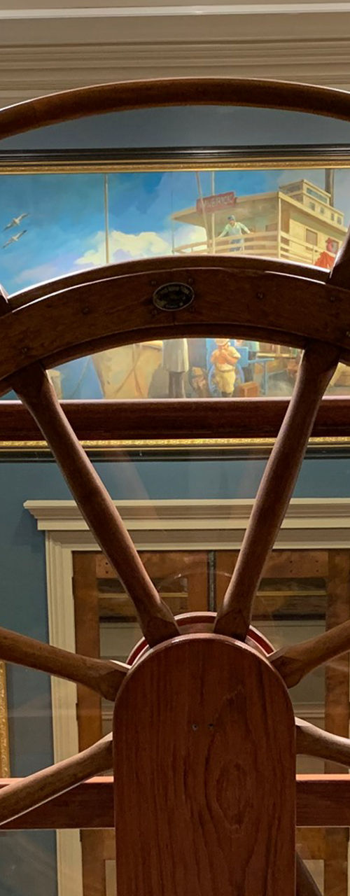 Large wooden ship wheel in museum exhibit