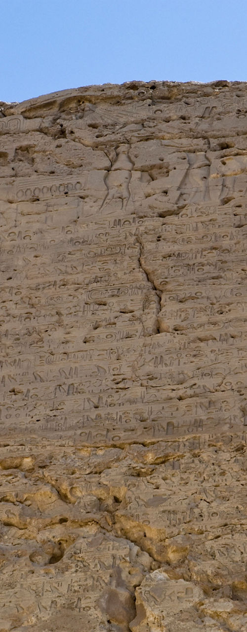 Ancient rock cliff with carved reliefs