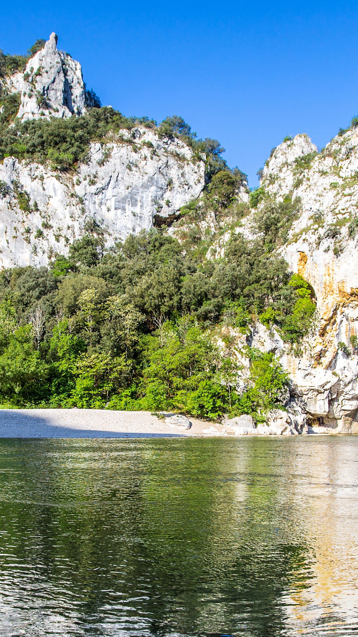 Natural stone arch over calm river