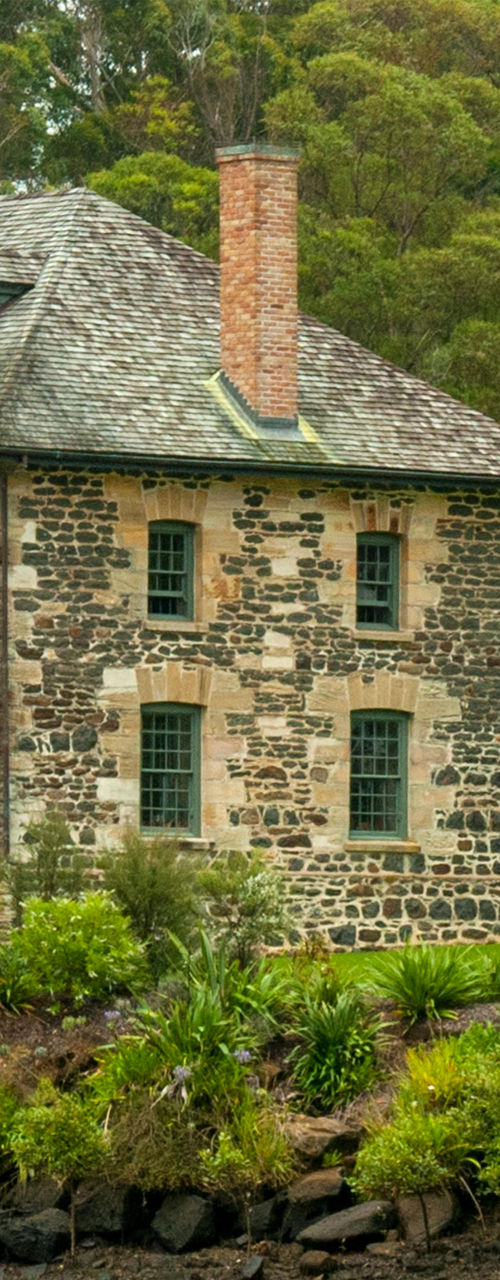 Historic stone house by riverside greenery