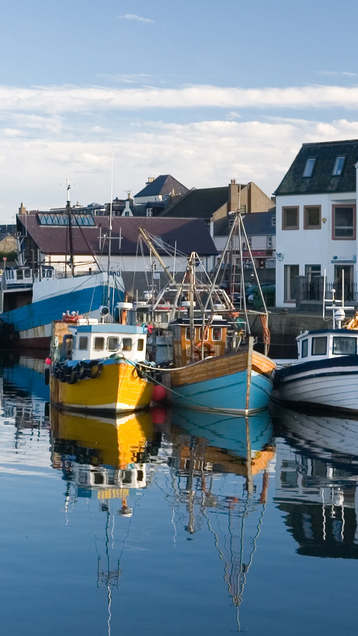 Colorful fishing boats docked at coastal harbor