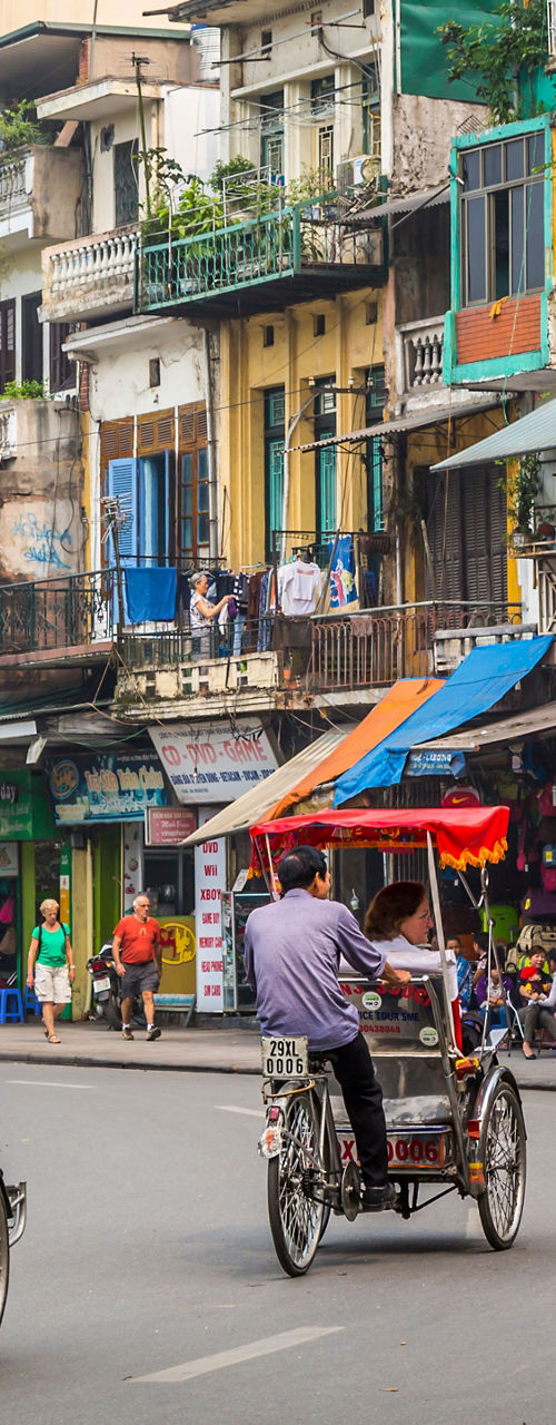 Cyclo riders in bustling Hanoi street