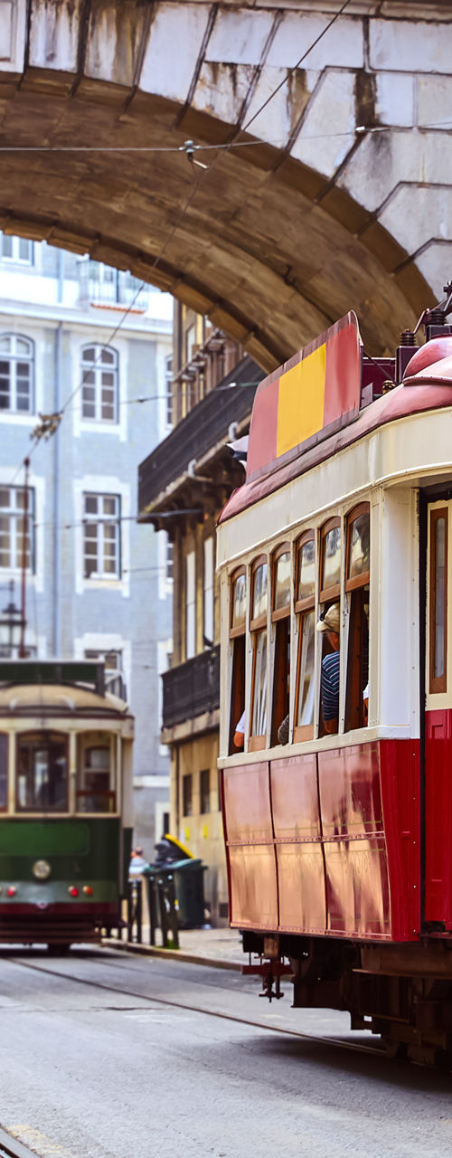 Historic red tram under Lisbon archway