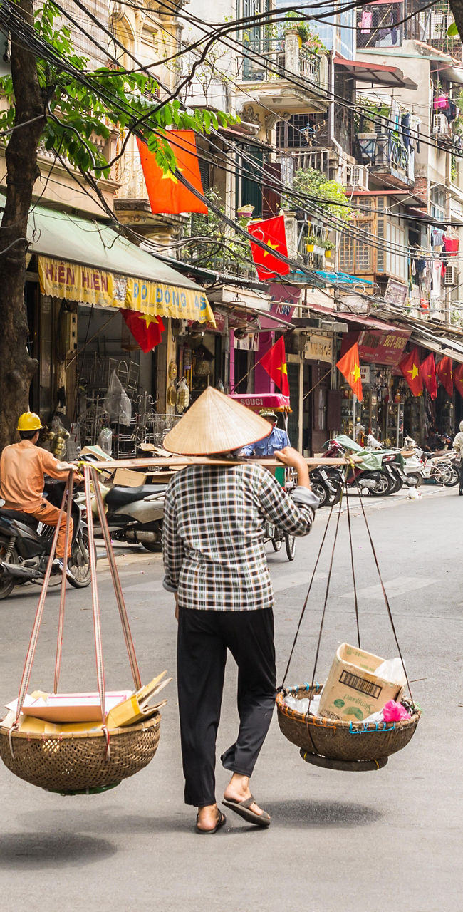 Street vendor carrying baskets in Hanoi