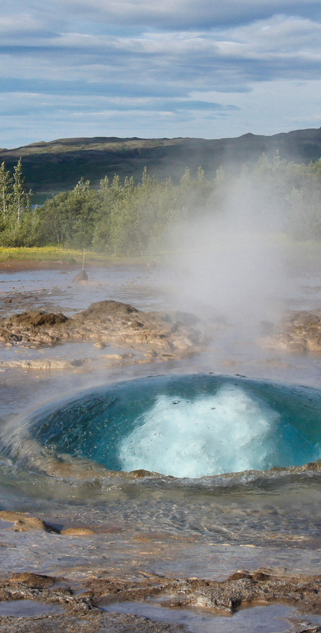 Geyser erupting in natural landscape