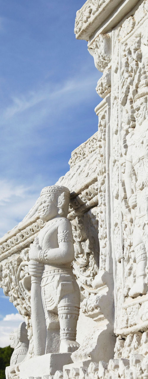 Intricate temple carvings with white pagoda