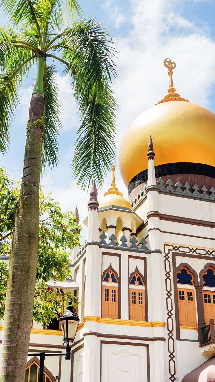 Golden-domed mosque with palm trees