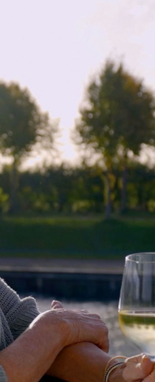 Woman enjoying wine by riverside view