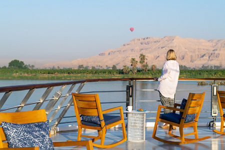 Woman enjoying river view with hot air balloon