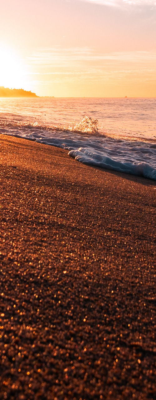 Sunrise over serene beach with waves