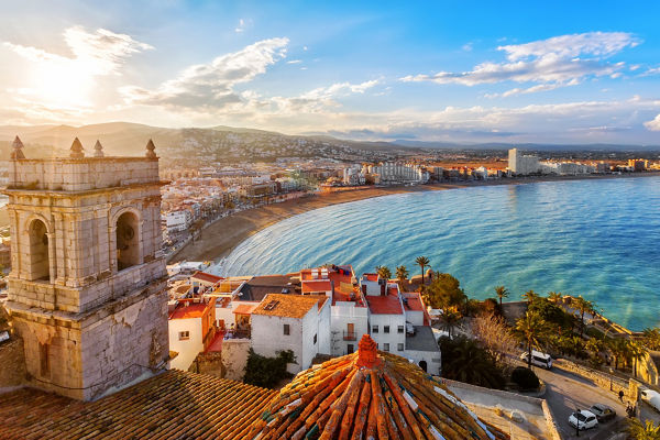 Coastal cityscape with beach and sunset