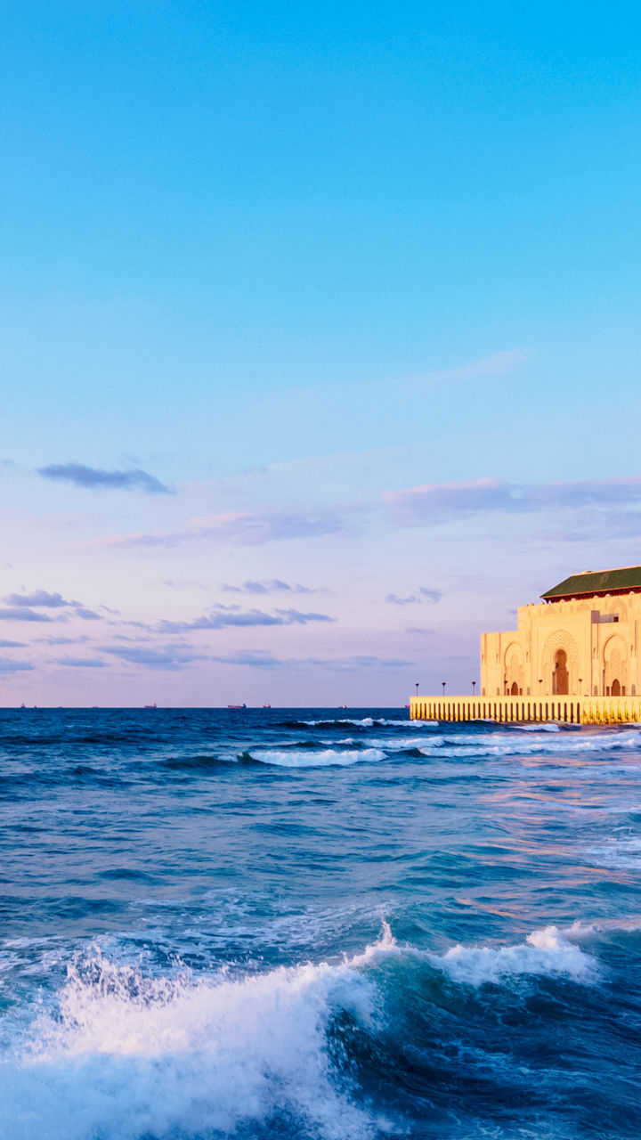 Hassan II Mosque by ocean at sunset