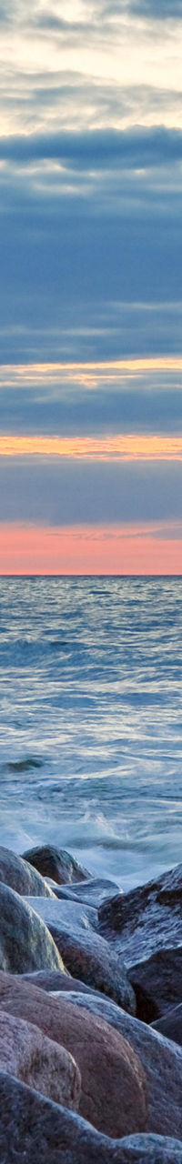 Rocky shoreline at sunrise with calm waves