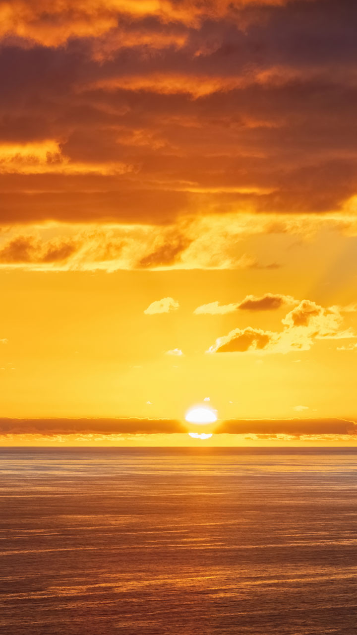 Golden sunset over calm ocean horizon