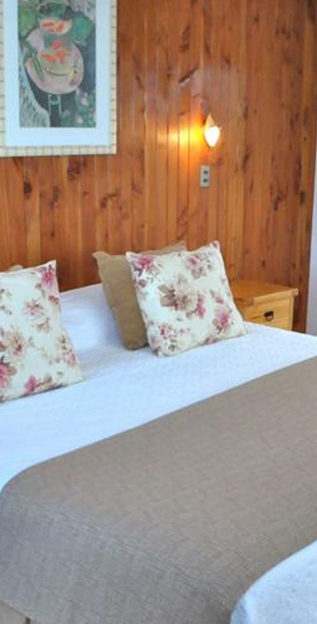 Cozy wooden bedroom with double bed