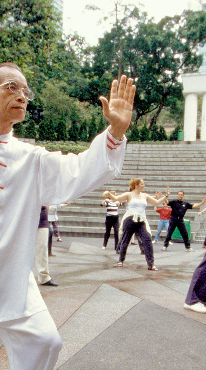 Group Tai Chi practice in outdoor setting