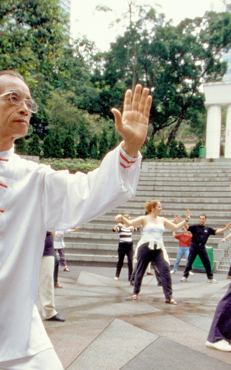 Group Tai Chi practice in outdoor setting
