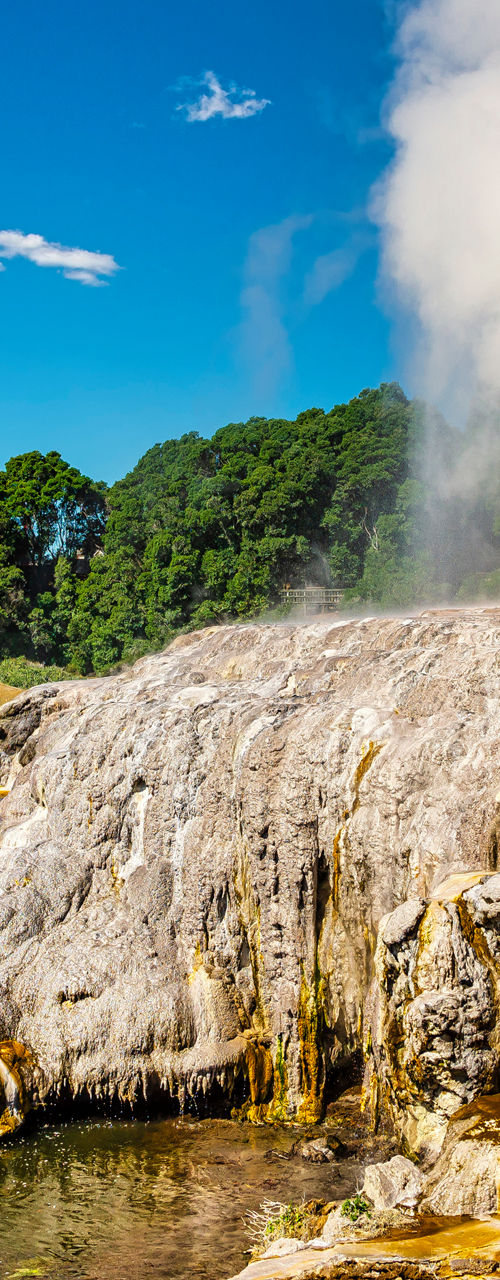 Natural geyser erupting in scenic landscape