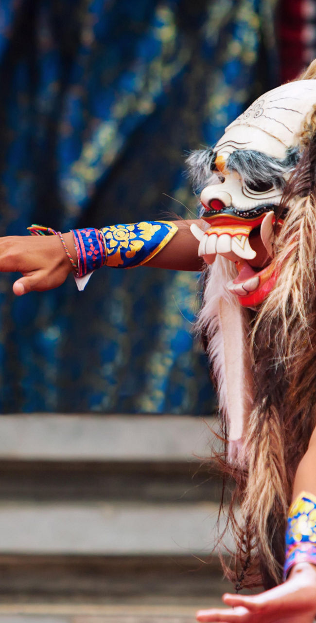 Traditional dancer in vibrant costume and mask