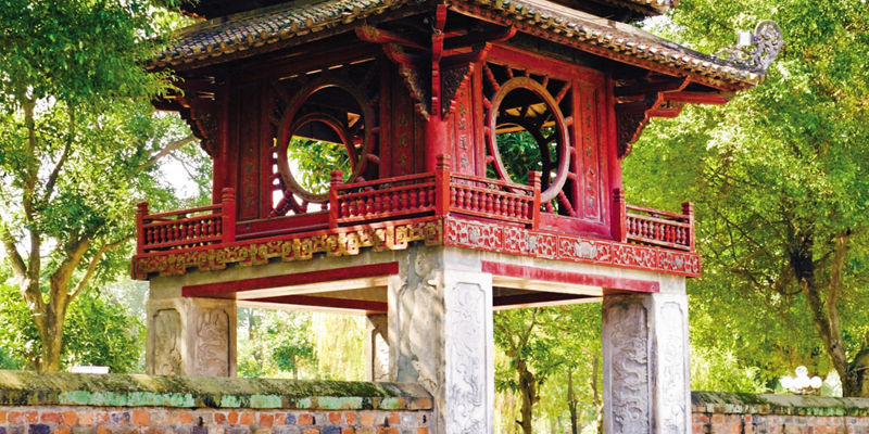 Ancient red pavilion in lush garden setting