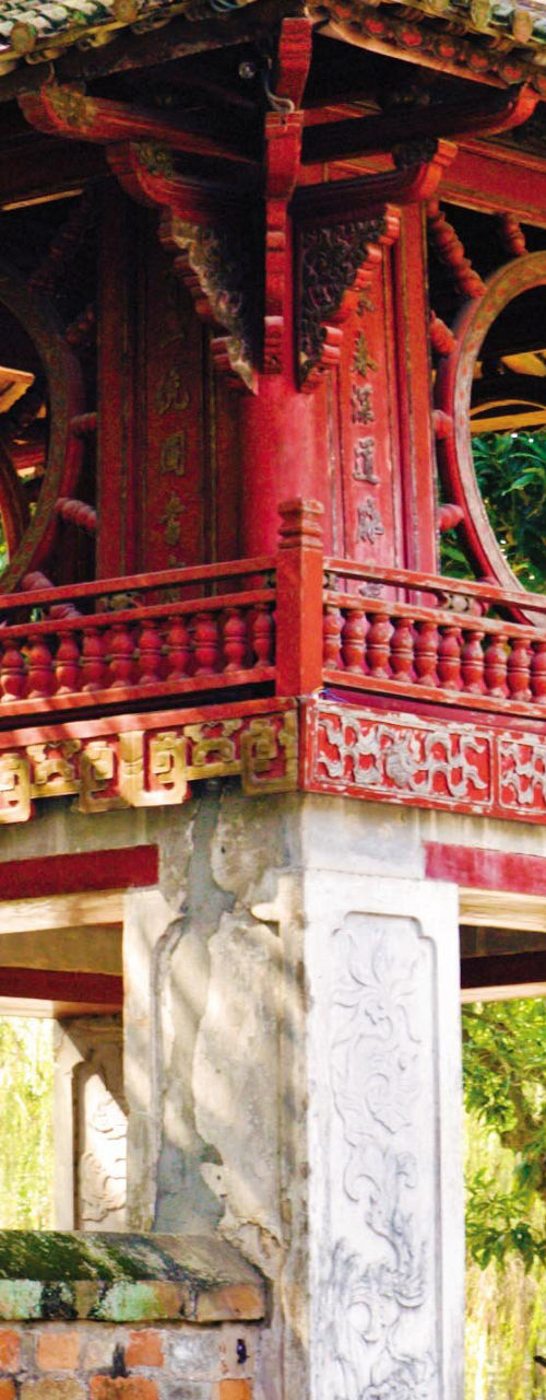 Ancient red pavilion in lush garden setting