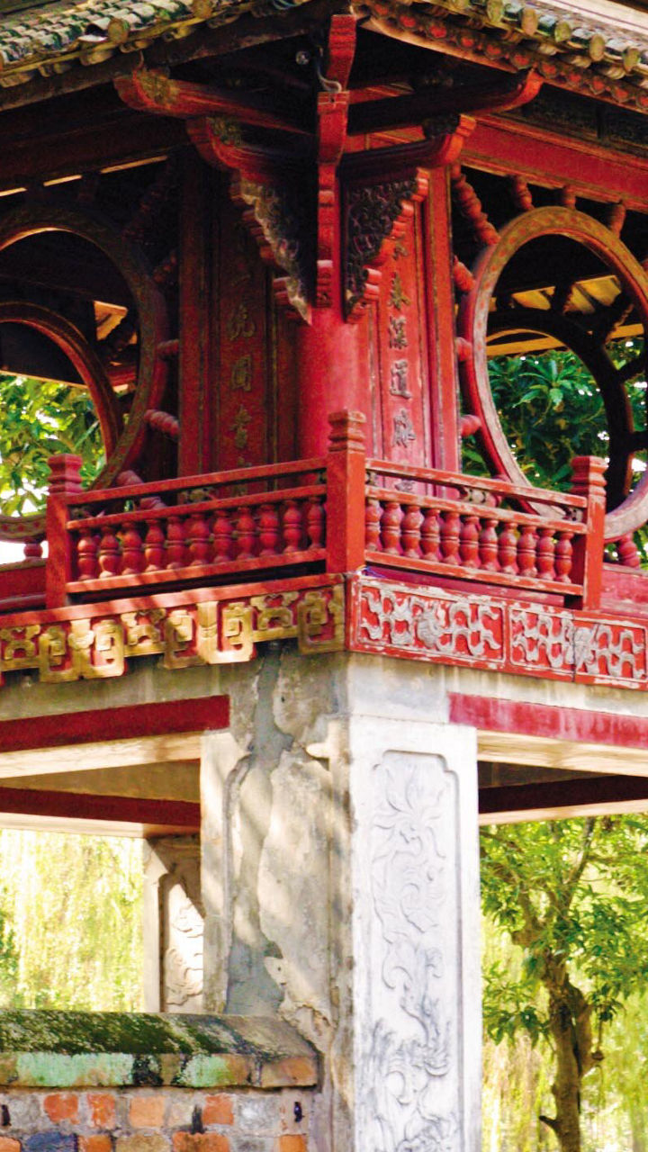 Ancient red pavilion in lush garden setting