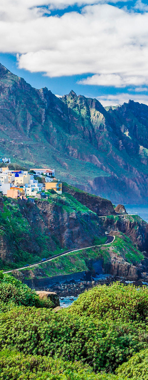 Coastal village with rugged mountain backdrop