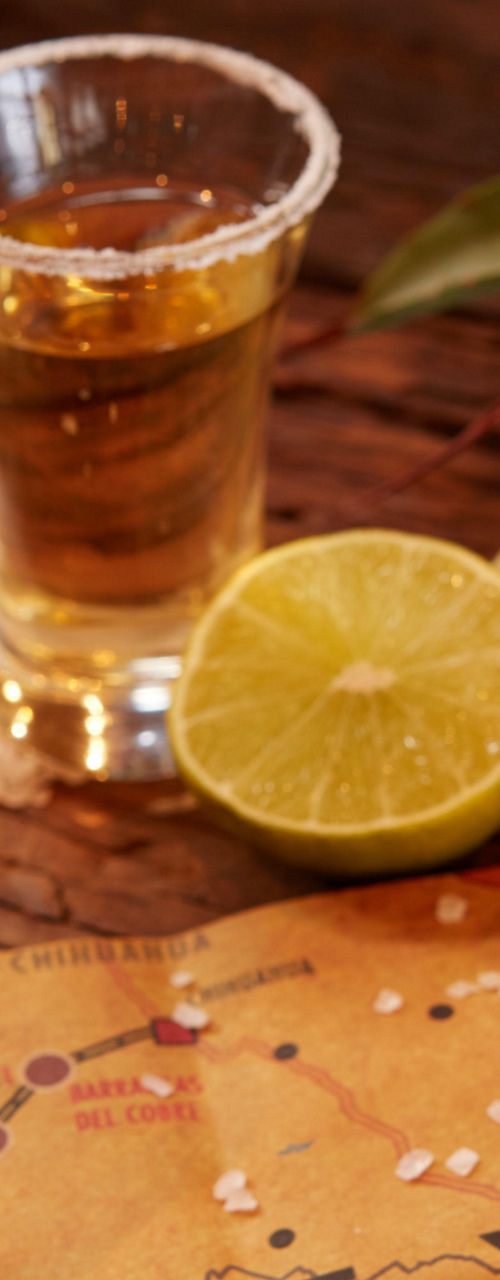 Tequila bottle and shots with lime garnish