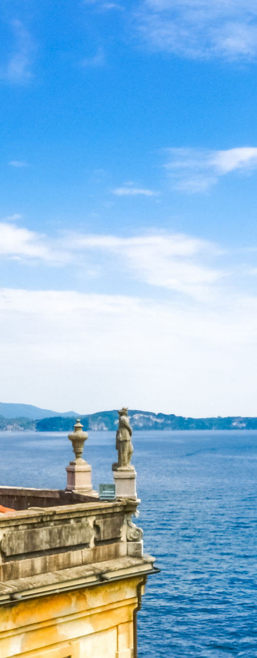 Lakeside garden with red roses and statue