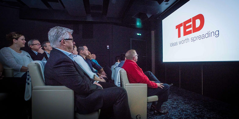 Audience watching TED presentation in theater