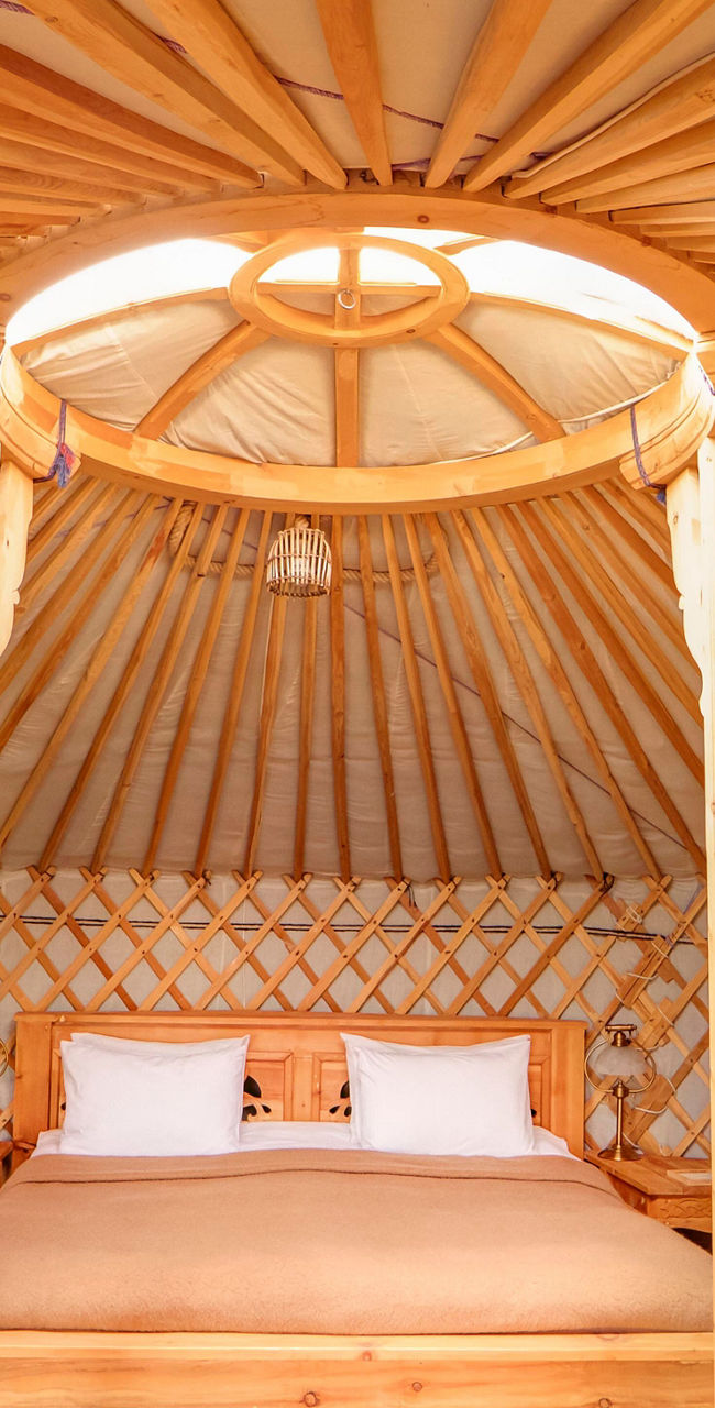 Cozy wooden yurt interior with bed