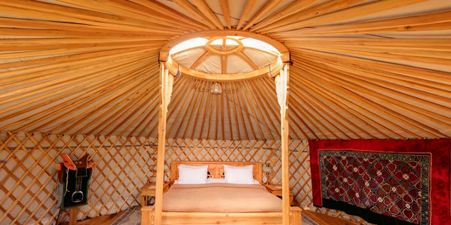 Cozy wooden yurt interior with bed