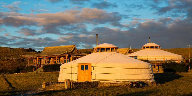 Traditional yurts in scenic sunset setting