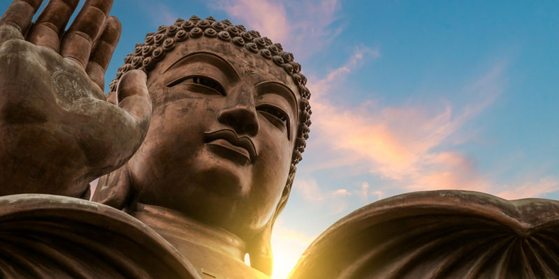 Large Buddha statue under vibrant sky