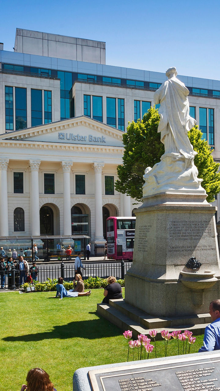 Sunny park with statue and city backdrop