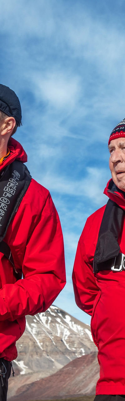 Group in red jackets exploring Arctic landscape