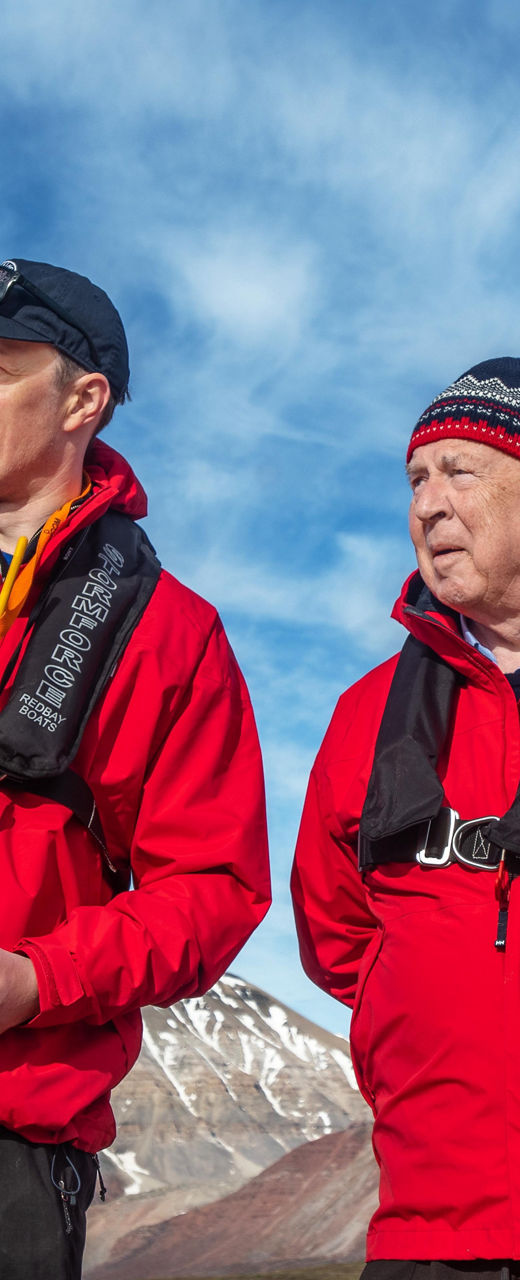 Group in red jackets exploring Arctic landscape
