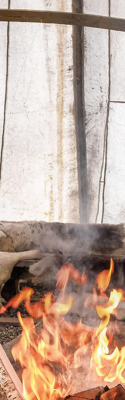 Person tending fire in rustic shelter