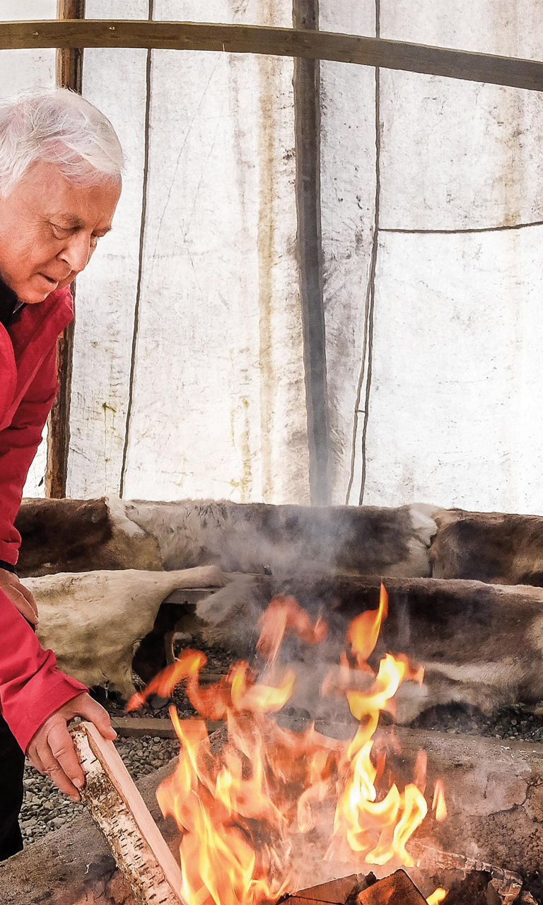 Person tending fire in rustic shelter