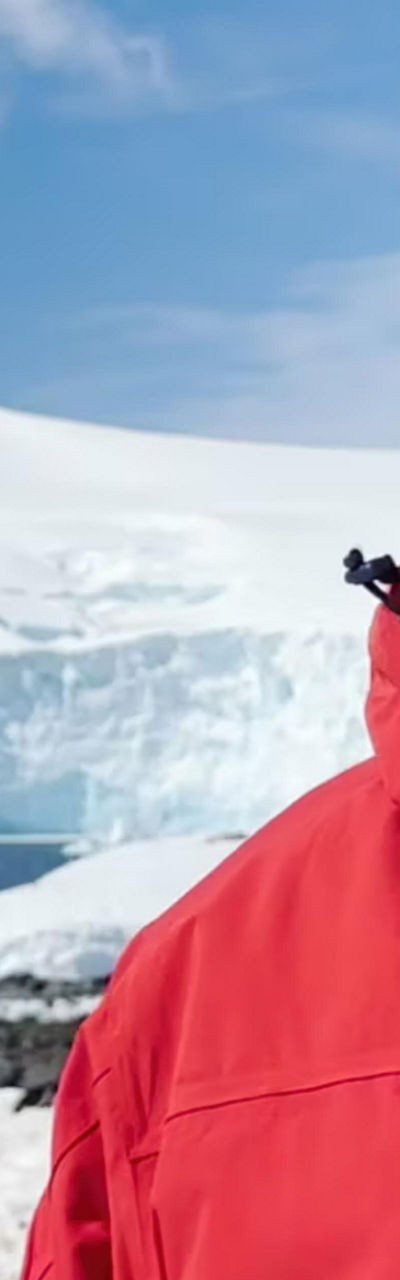 Person in red jacket near snowy mountain