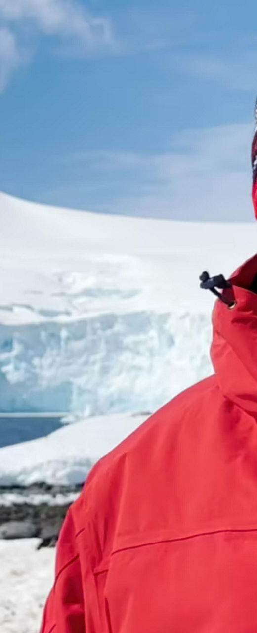Person in red jacket near snowy mountain