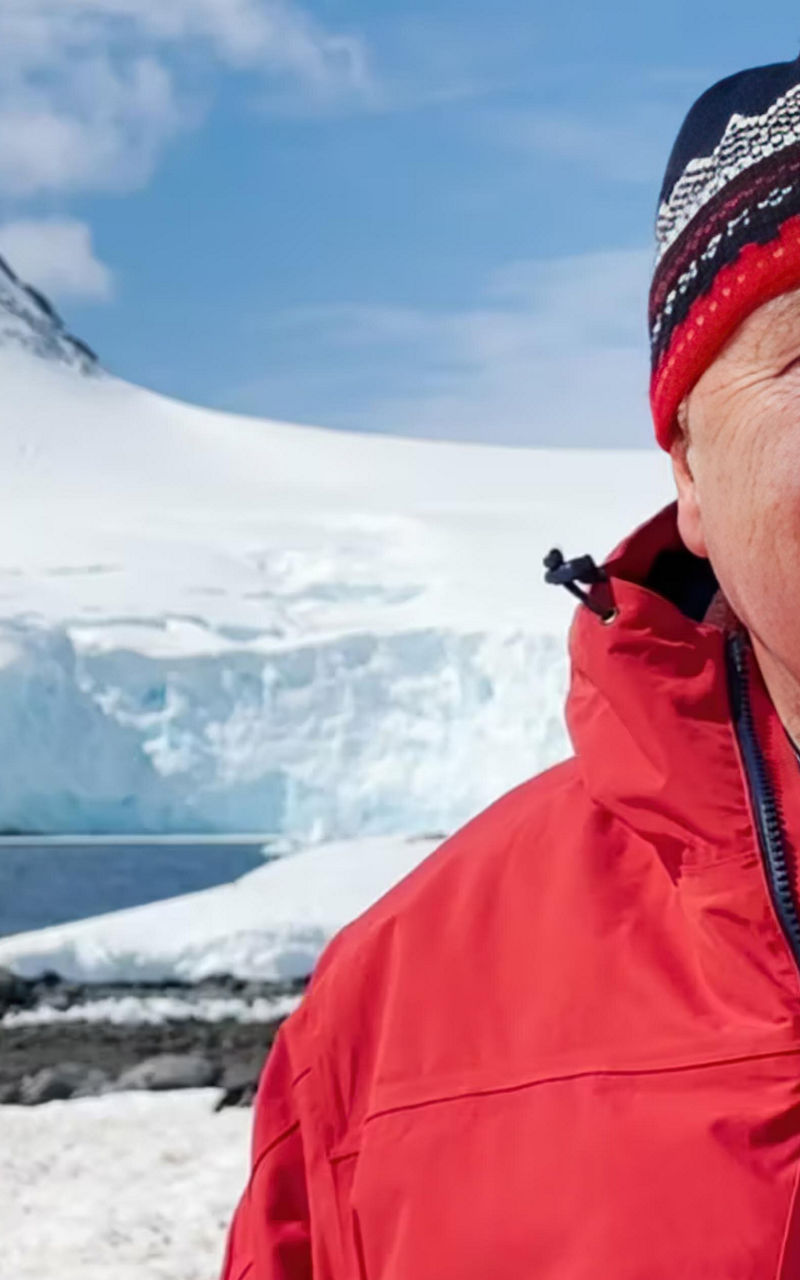 Person in red jacket near snowy mountain