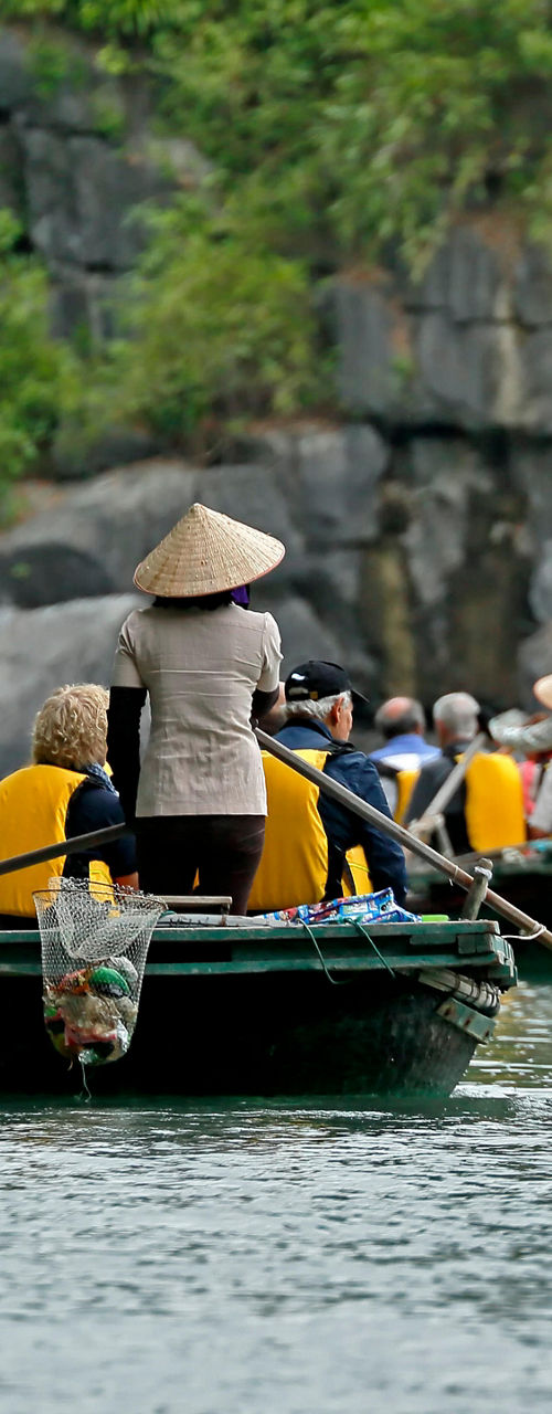 Group rowing boats in scenic limestone setting