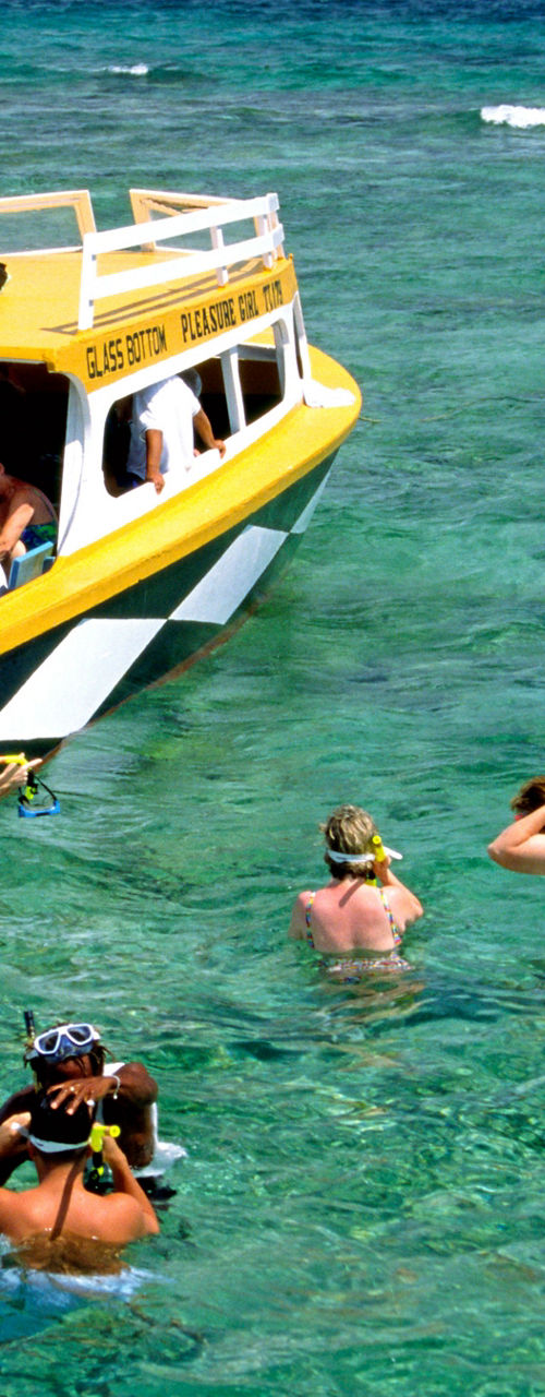 Snorkeling group near yellow boat in tropical waters