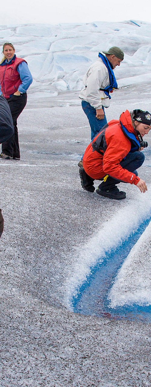Explorers examining glacier streams outdoors
