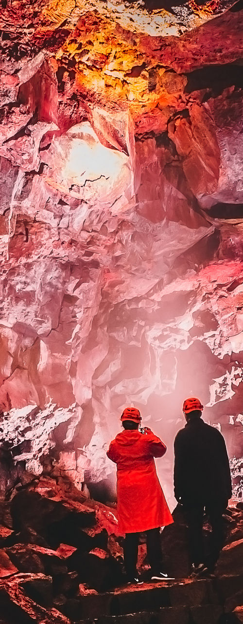 Explorers in illuminated volcanic cave